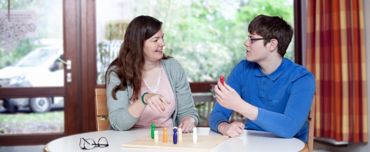 Psychologin und Klient spielen ein Brettspiel.