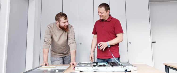 Auszubildender und Anleiter am Serverkasten.