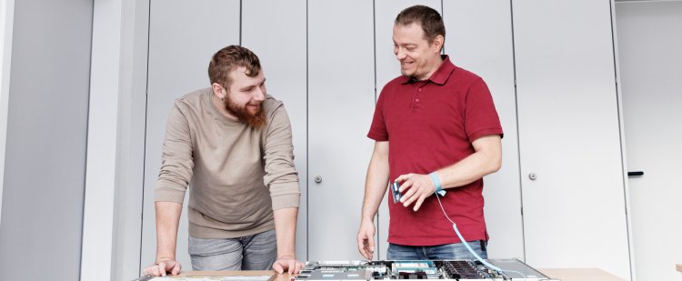 Auszubildender und Anleiter am Serverkasten.