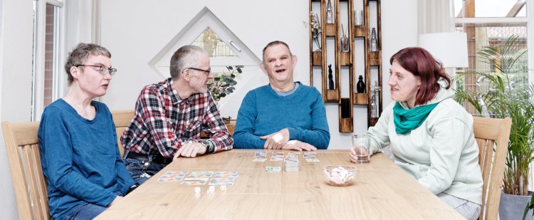 Vier Bewohnerinnen und Bewohner beim Gesellschaftsspiel.