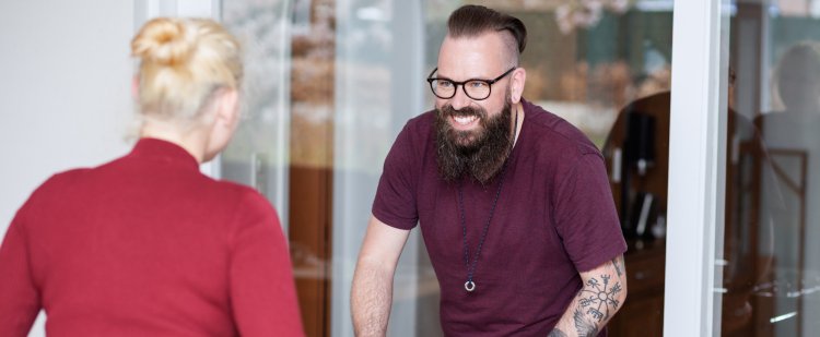 Erzieher und Klientin spielen Tischkicker gegeneinander.