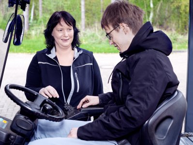 Wirtschaftswirtin zeigt einem Beschäftigen die Bedienung eines Gabelstaplers.