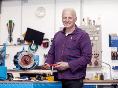 Maschinenbauer schraubt mit Schraubenzieher an einer Maschine.