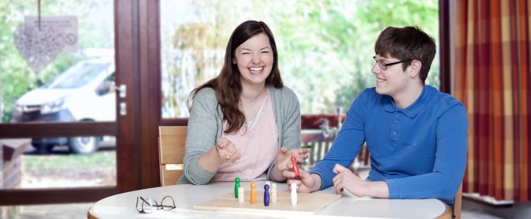 Psychologin und Klient spielen ein Brettspiel.